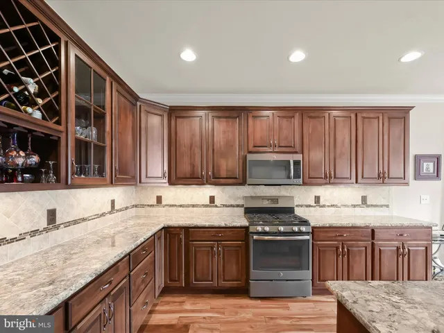 a kitchen with stainless steel appliances granite countertop wooden cabinets a stove top oven a sink and dishwasher