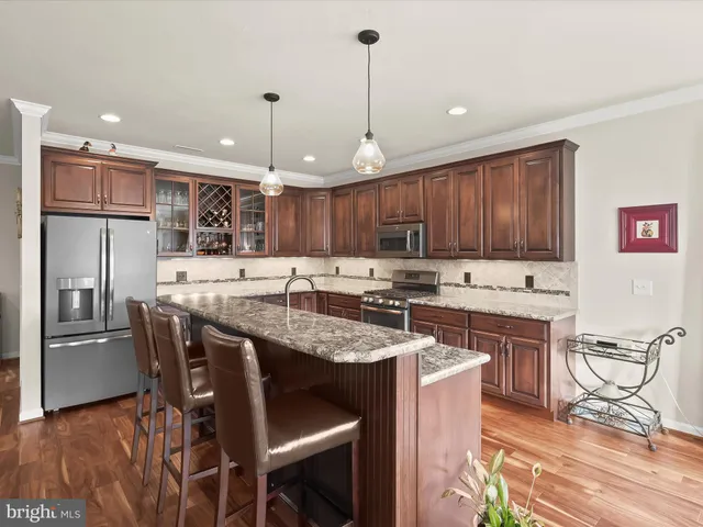 a kitchen with granite countertop a center island a sink stainless steel appliances and cabinets