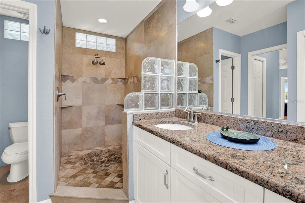 203 163rd Avenue Redington Beach, FL 33708 - Photo 22 of 31 a bathroom with a granite countertop sink a toilet and shower