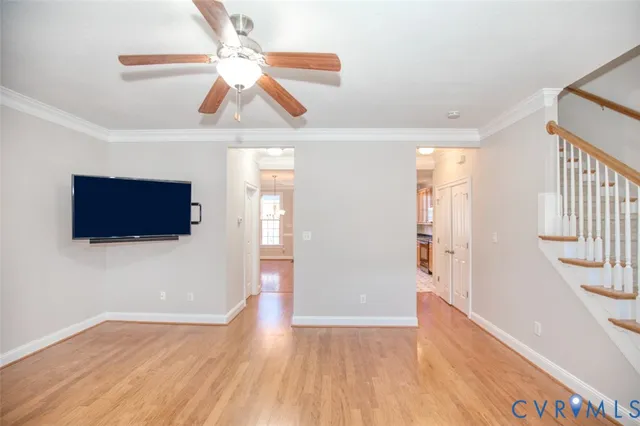 a view of a livingroom with wooden floor and a ceiling fan