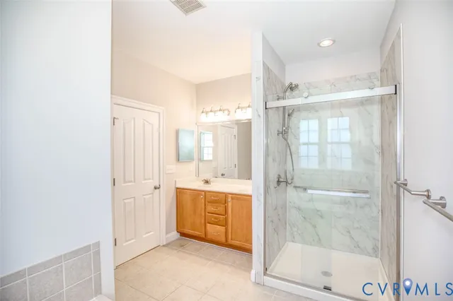 a bathroom with a tub shower sink and mirror
