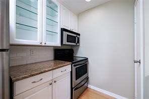 18617 Egret Bay Boulevard, Unit 708 Webster, TX 77058 - Photo 5 of 19 a kitchen with granite countertop cabinets stainless steel appliances and a window