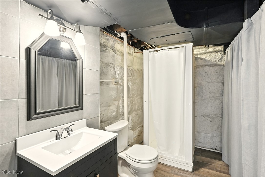 2844 Kent Road Stow, OH 44224 - Photo 37 of 47 Bathroom with tile walls, vanity, a shower stall, and wood finished floors