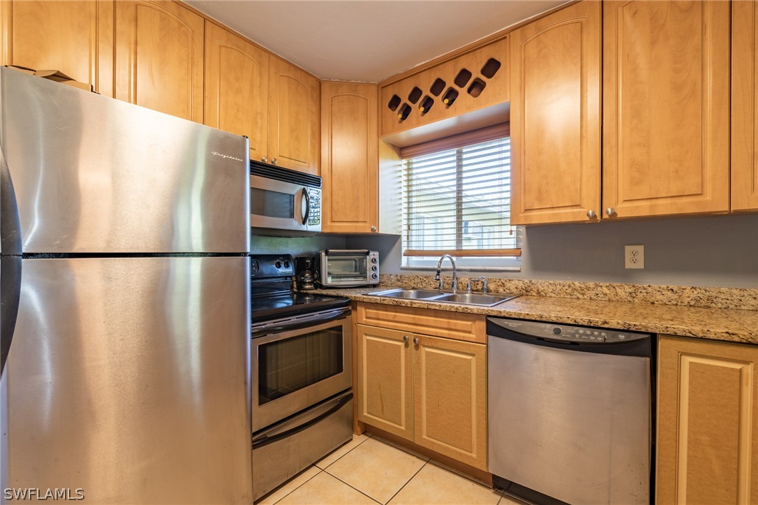 8162 Country Road, Unit 203 Fort Myers, FL 33919 - Photo 4 of 22 a kitchen with stainless steel appliances granite countertop a refrigerator and a sink