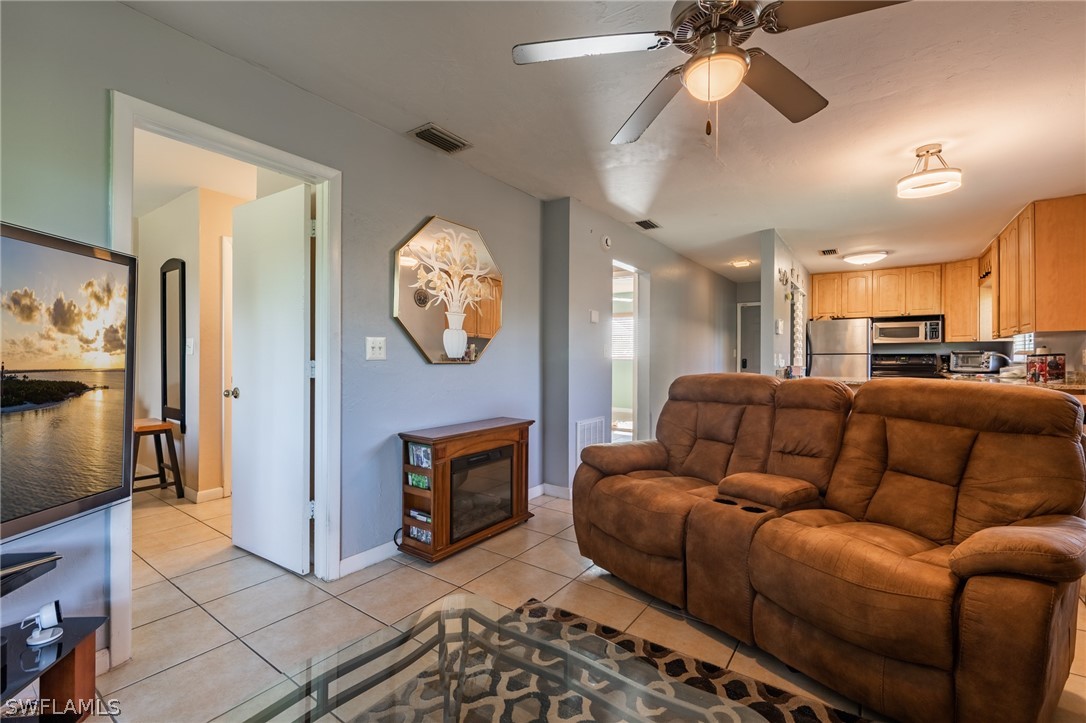 8162 Country Road, Unit 203 Fort Myers, FL 33919 - Photo 9 of 22 a living room with furniture a fireplace and a flat screen tv