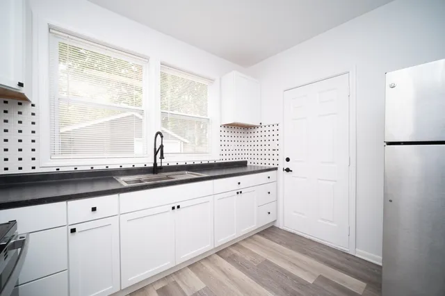 a kitchen with granite countertop white cabinets and a window