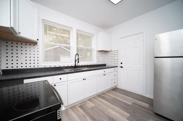 a kitchen with granite countertop white cabinets and white appliances