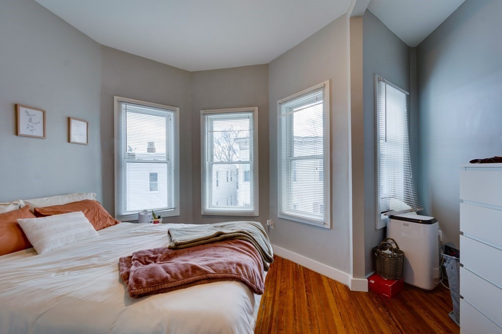 15 Hecla Street Boston, MA 02122 - Photo 23 of 33 a bedroom with a bed next to a window with wooden floor