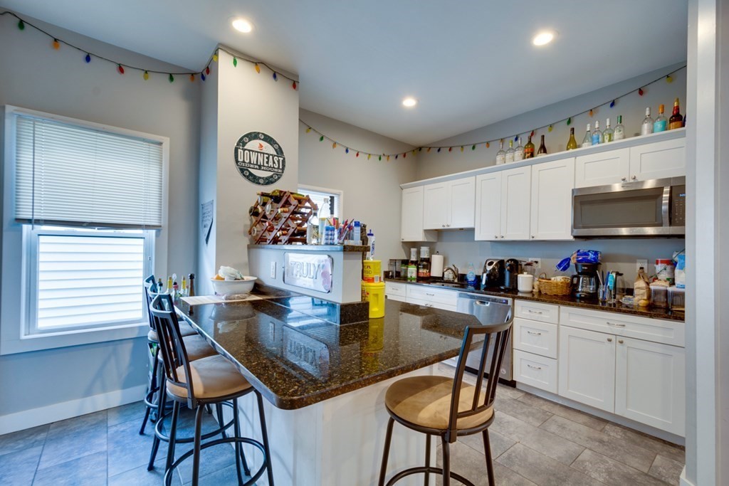 15 Hecla Street Boston, MA 02122 - Photo 3 of 33 a kitchen with a dining table cabinets and appliances