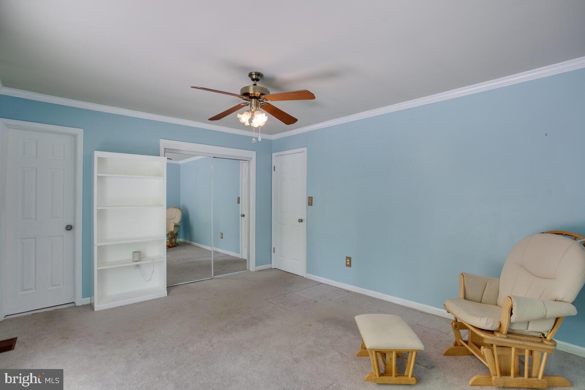 1420 Wilson Road Huntingtown, MD 20639 - Photo 28 of 43 a view of a livingroom with a chair and a chandelier fan