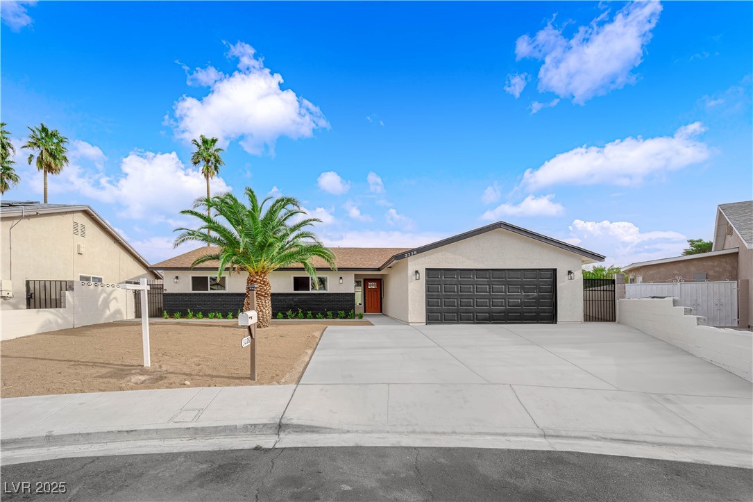 Ranch-style home featuring a garage, fence, concre