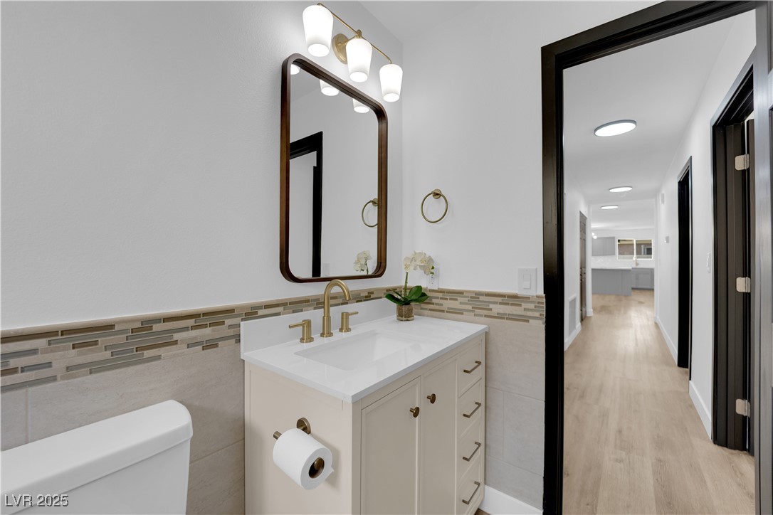 3228 Robin Circle Las Vegas, NV 89121 - Photo 29 of 45 Half bath featuring tile walls, toilet, wainscotin