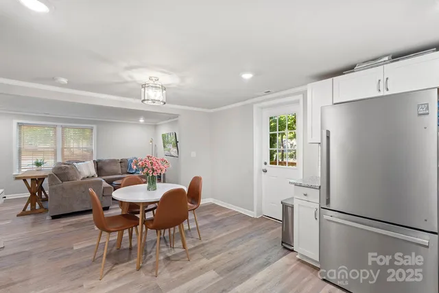 a view of a dining room with furniture and a refrigerator