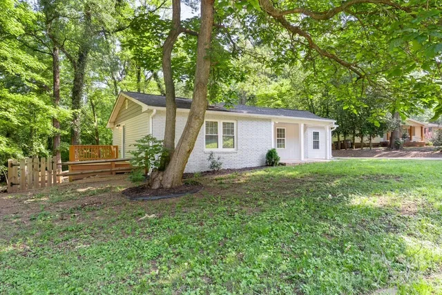 a view of a house with backyard and a tree