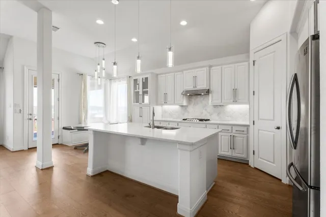 a kitchen with stainless steel appliances granite countertop a sink stove and cabinets