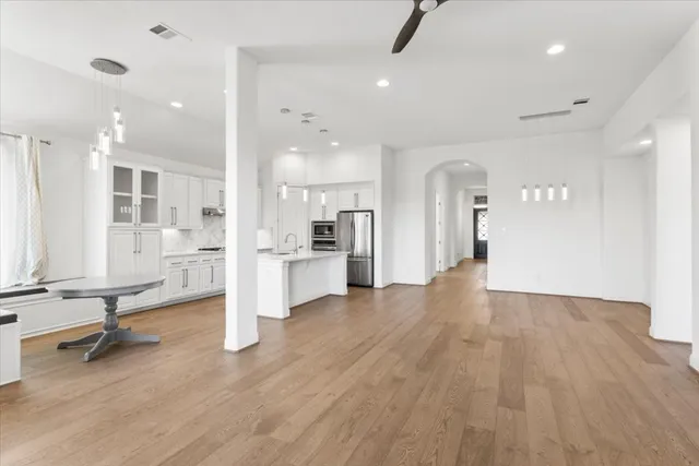 a view of kitchen with refrigerator stove and wooden floor