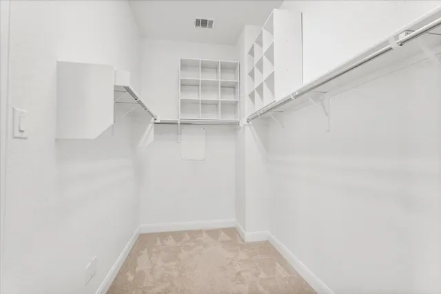 a view of walk in closet with empty racks
