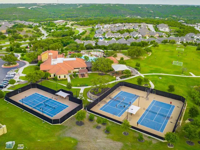 an aerial view of a pool yard and mountain view in back