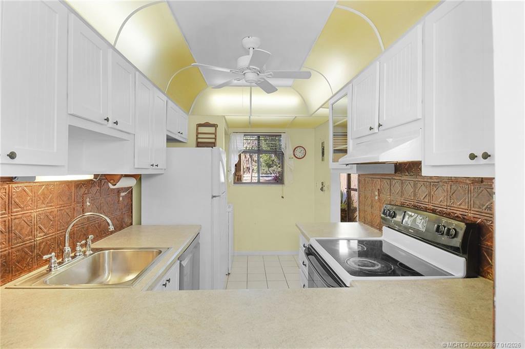 5303 Southeast Miles Grant Road, Unit L101 Stuart, FL 34997 - Photo 11 of 54 a kitchen with stainless steel appliances granite countertop a sink a stove and a refrigerator