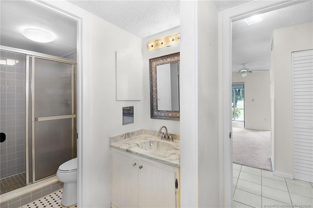 5303 Southeast Miles Grant Road, Unit L101 Stuart, FL 34997 - Photo 22 of 54 a bathroom with a granite countertop sink toilet and shower