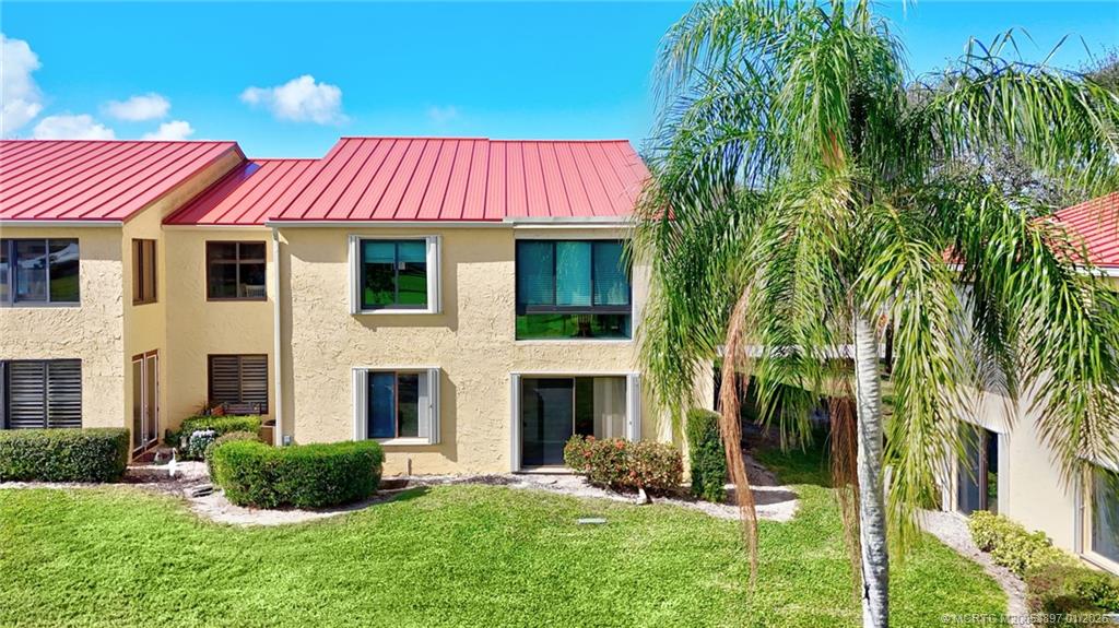 5303 Southeast Miles Grant Road, Unit L101 Stuart, FL 34997 - Photo 53 of 54 a front view of a house with a yard