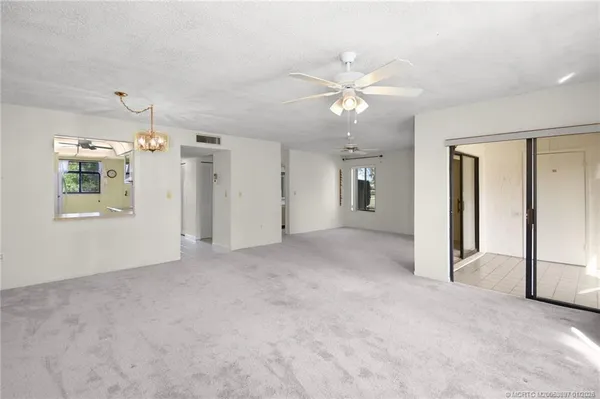 a view of a big room with chandelier fan and windows