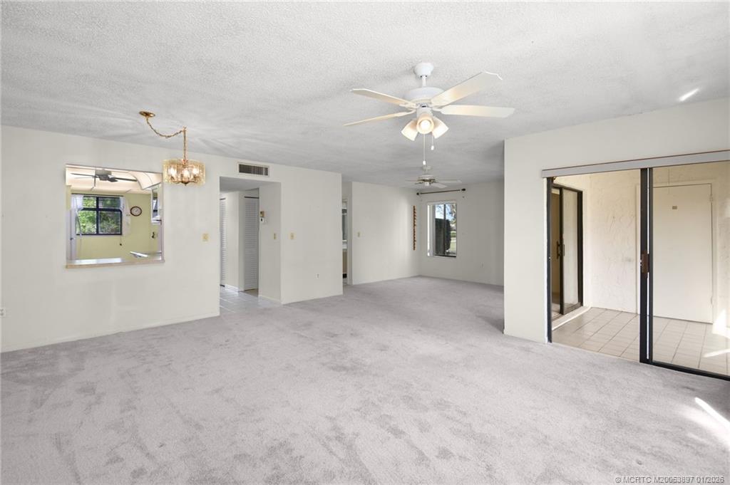 5303 Southeast Miles Grant Road, Unit L101 Stuart, FL 34997 - Photo 6 of 54 a view of a big room with chandelier fan and windows
