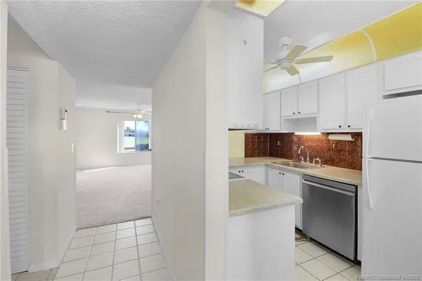 a kitchen with white cabinets and appliances