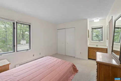 a bedroom with a bed and a dresser next to a window