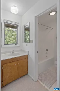 a bathroom with a tub sink and mirror