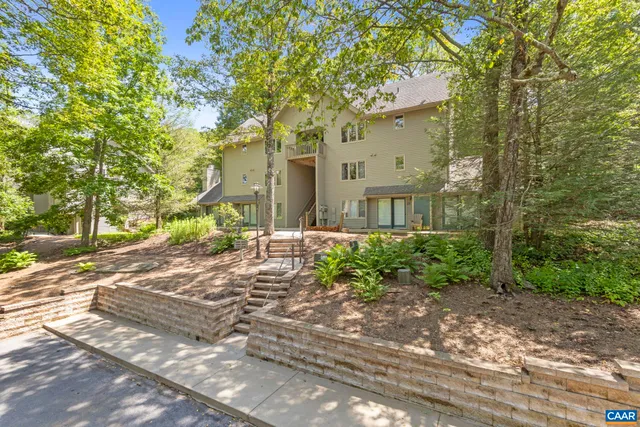 a yellow house with lots of trees