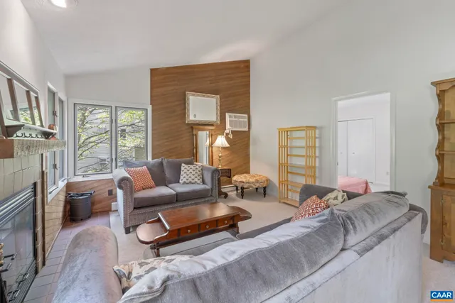 a living room with furniture wooden floor and a large window