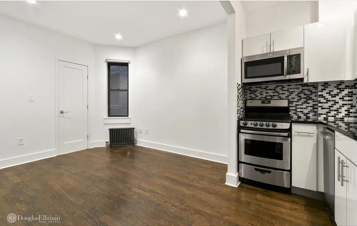 a kitchen with granite countertop a stove and a microwave