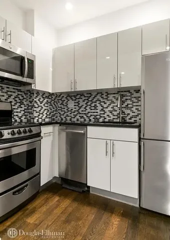 a kitchen with granite countertop a stove and a microwave