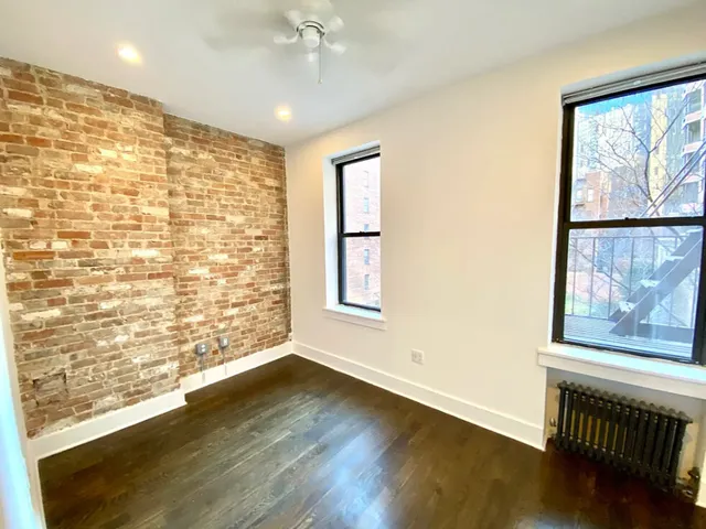 an empty room with wooden floor and fireplace