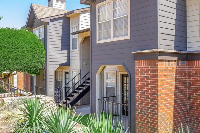 a kitchen with stainless steel appliances granite countertop a sink a stove a refrigerator a dining table and chairs with wooden floor