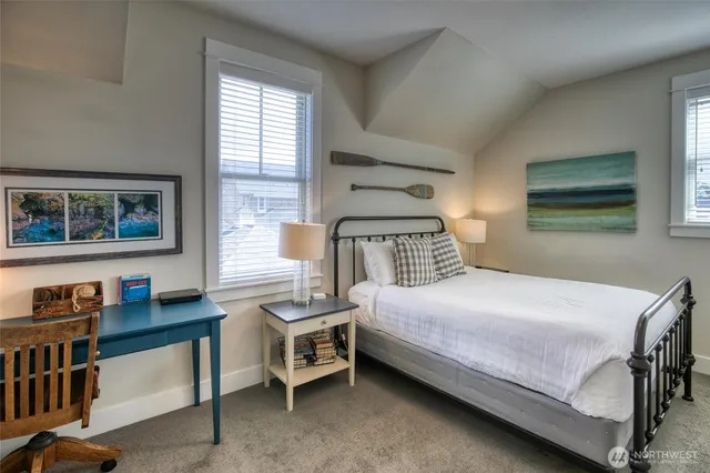 a bedroom with a bed wooden floor and window