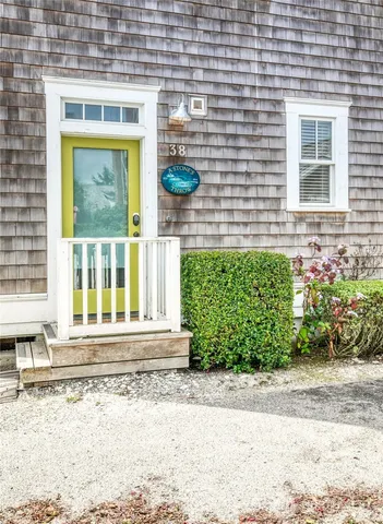 a front view of a house with a yard and potted plants