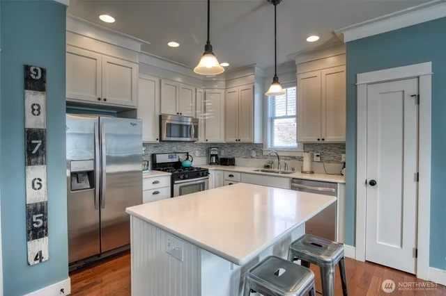 a kitchen with kitchen island a large counter top space appliances and cabinets