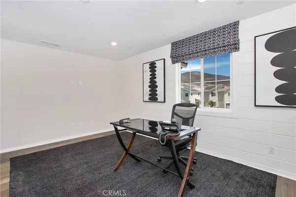 a view of a livingroom with a piano and wooden floor