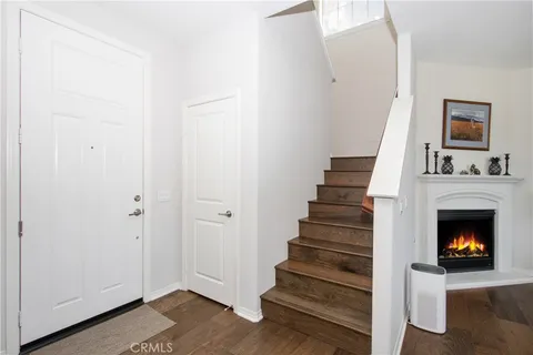 a view of an empty room with wooden floor fireplace and staircase