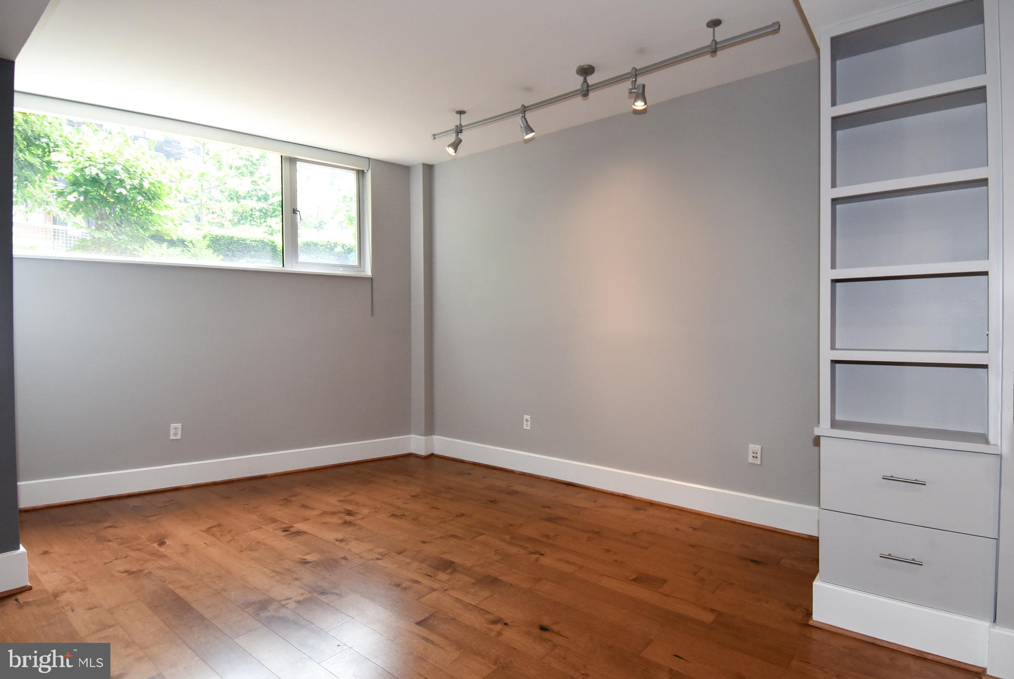 2100 11th Street Northwest, Unit G02 Washington, DC 20001 - Photo 14 of 36 a view of an empty room with a window and wooden floor