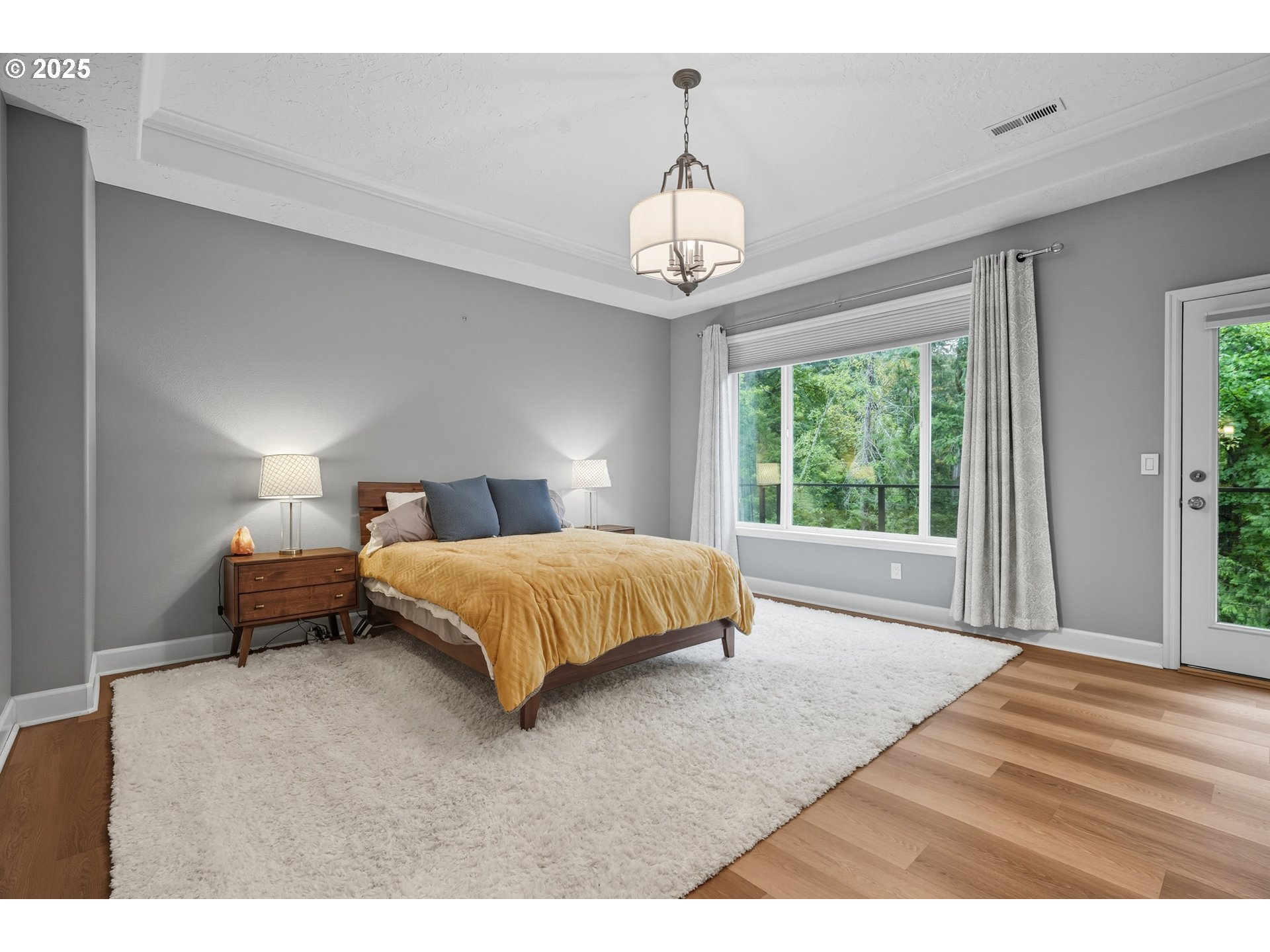 1109 Northwest Frazier Court Portland, OR 97229 - Photo 18 of 44 a spacious bedroom with a bed and a chandelier