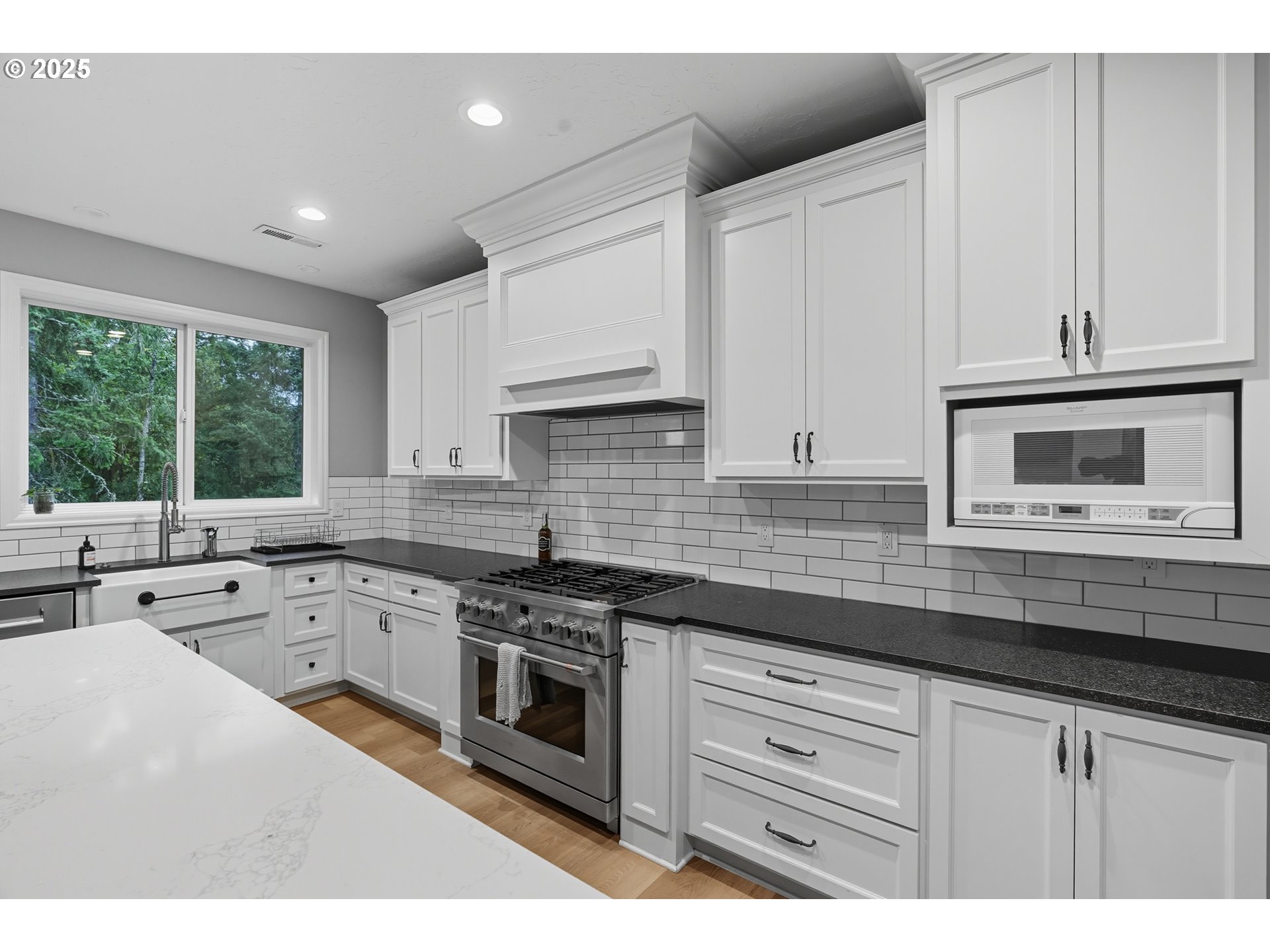 1109 Northwest Frazier Court Portland, OR 97229 - Photo 9 of 44 a kitchen with granite countertop a sink stainless steel appliances and white cabinets