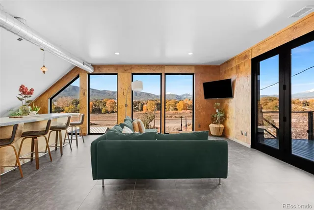a living room with furniture and floor to ceiling window