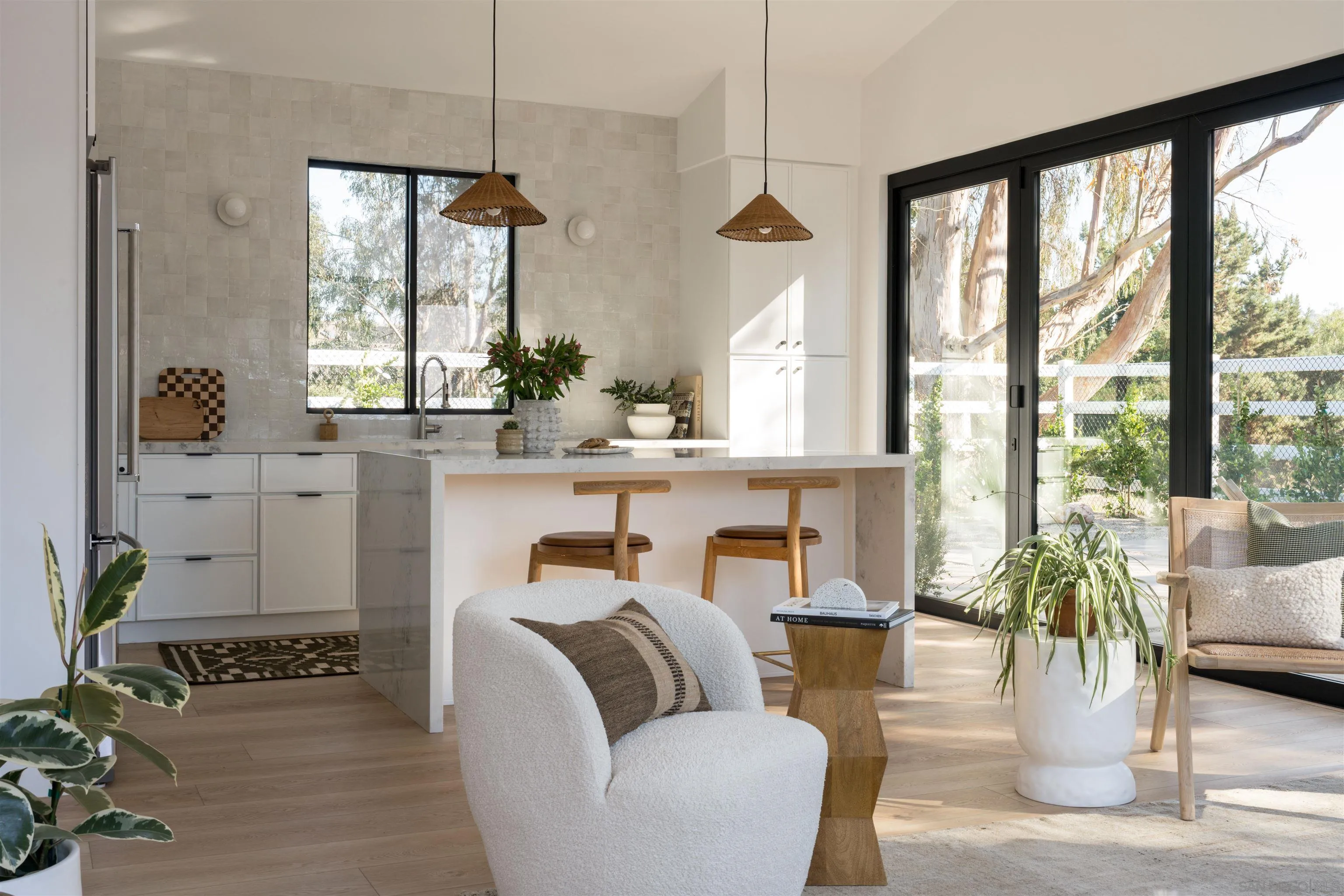a living room with furniture a potted plant and a large window