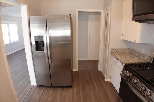 a kitchen with a refrigerator and a stove top oven