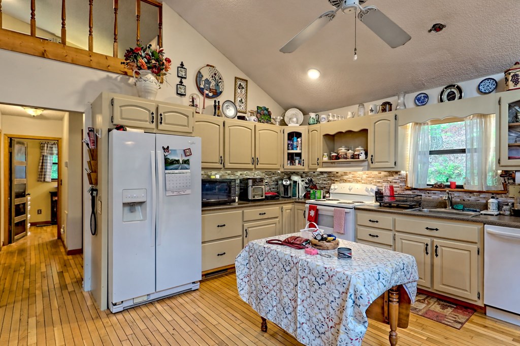 773 Rolling Oaks Road Murphy, NC 28906 - Photo 16 of 72 a kitchen with stainless steel appliances kitchen island granite countertop a refrigerator a sink dishwasher and white cabinets with wooden floor