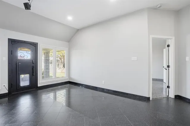 a view of an empty room with a fireplace and a window