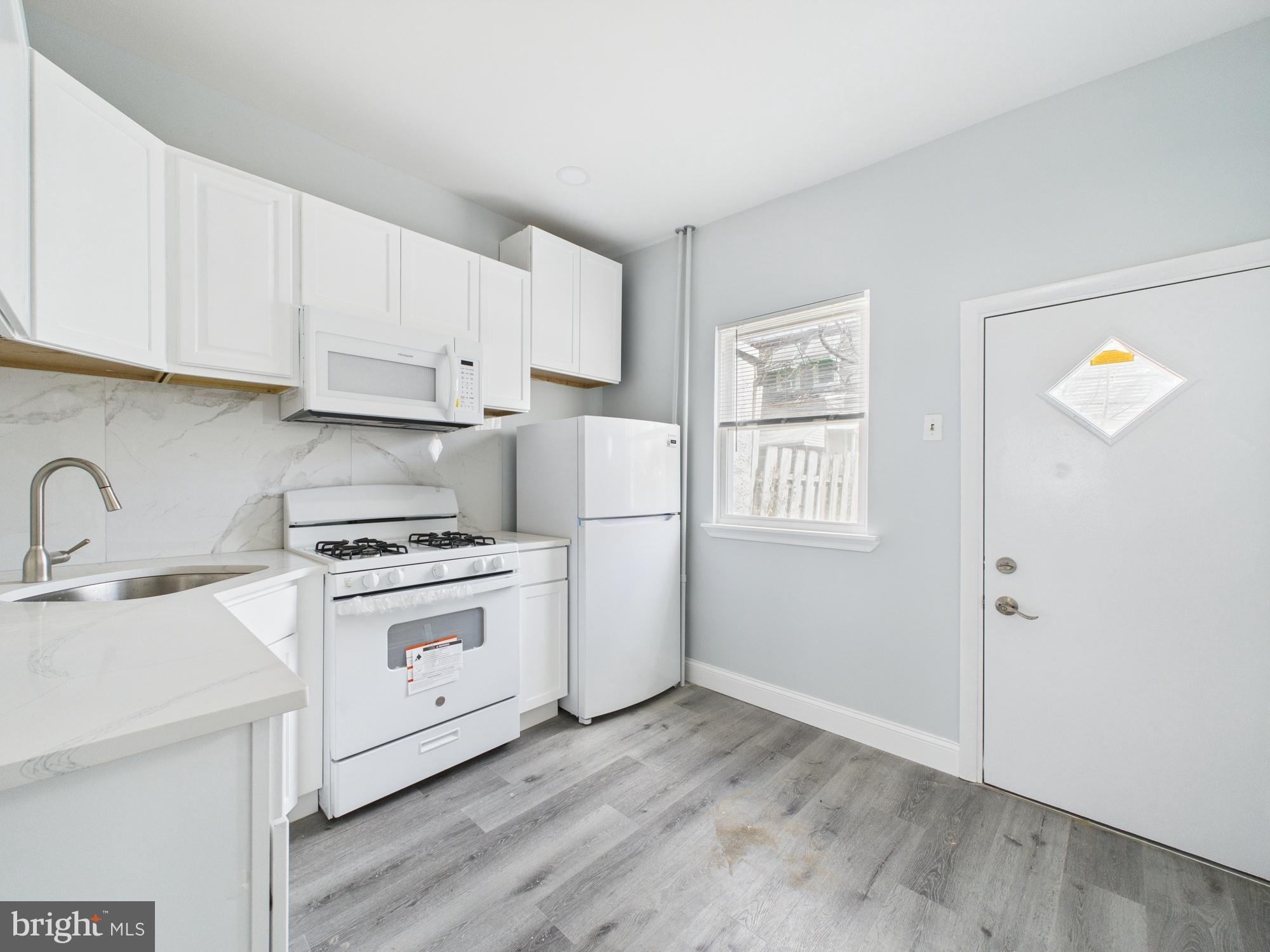 2021 Granite Street Philadelphia, PA 19124 - Photo 2 of 9 a kitchen with granite countertop a stove a sink and a refrigerator